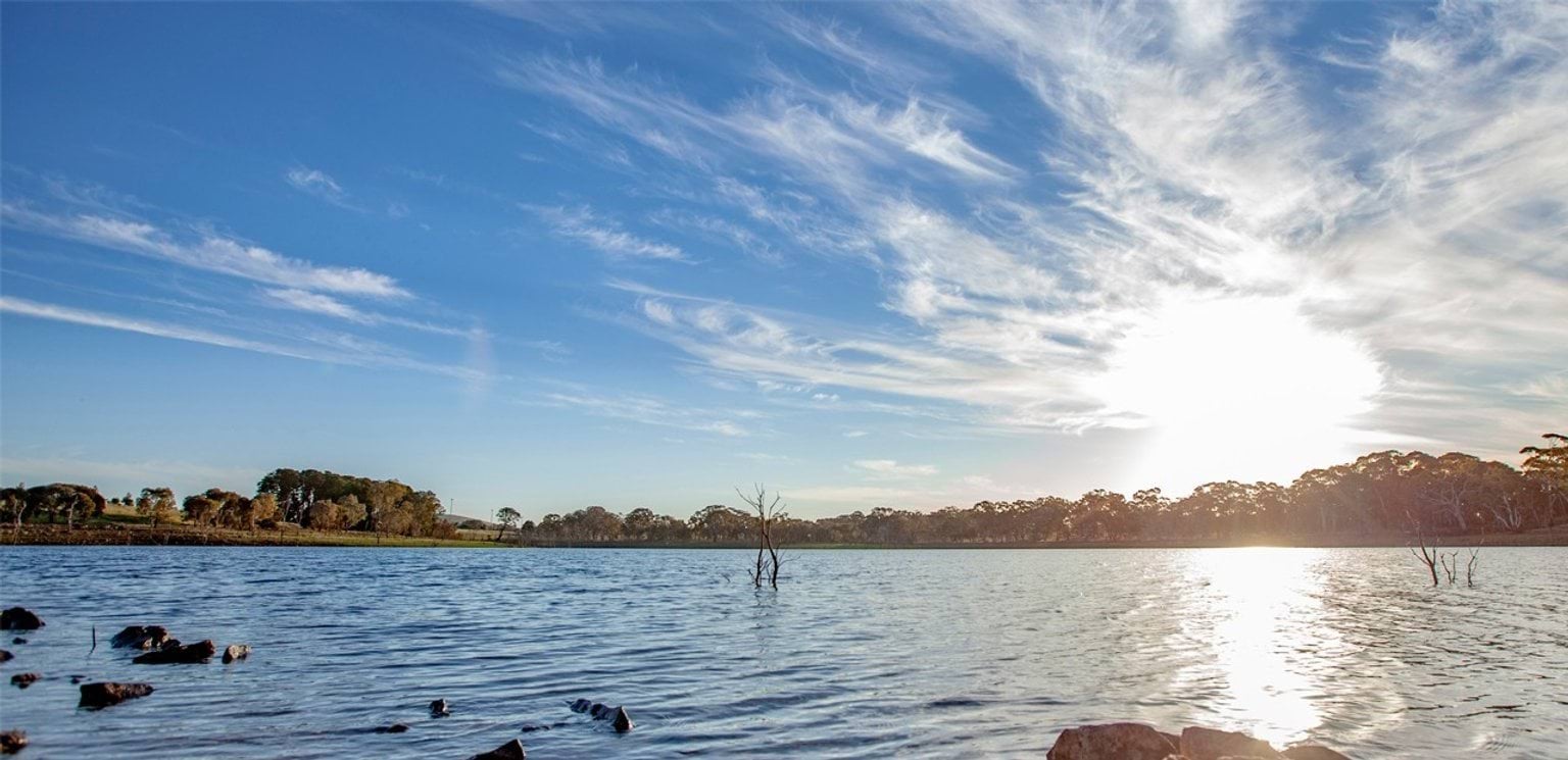 Image of reservoir with sun shinning through clouds